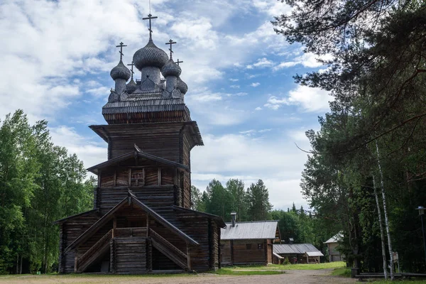 Старая деревянная православная церковь с колокольней на фоне голубого неба. Традиционная древняя архитектура севера России — стоковое фото