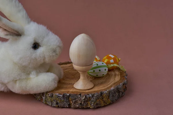 Klein wit konijntje in de omtrek met verschillende kleuren ester eieren. — Stockfoto