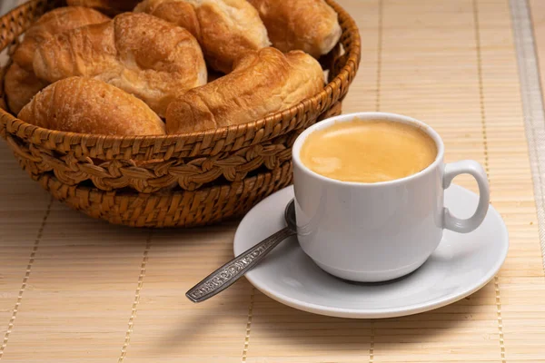 Café com croissants frescos em uma cesta de vime. Foco seletivo — Fotografia de Stock