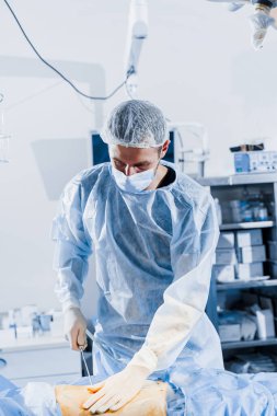 Abdominoplasti, karın bölgesini küçültmek ve selüloit çıkarmak için estetik ameliyat. Vücut şeklini düzeltiyorum. Cerrah klinikte hastaya liposuction yapıyor.