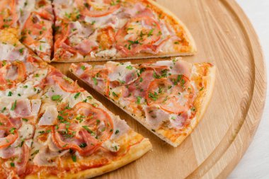 Pizza üst görüntüsü 8 parçadan kesilmiş ve biri ileri itilmiş. Pizzacı kafe ve restoran için reklam. Yemek teslimatı karantina covid-19 konseptinde.