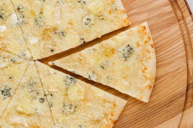 Pizza üst görüntüsü 8 parçadan kesilmiş ve biri ileri itilmiş. Pizzacı kafe ve restoran için reklam. Yemek teslimatı karantina covid-19 konseptinde.