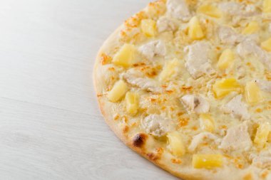 Beyaz ahşap arka planda izole edilmiş ananas, tavuk, peynir ve soslu Hawaii pizzası. Lokantalar, kafeler için sosyal ağ ilanı. Pizzacı için tanıtım