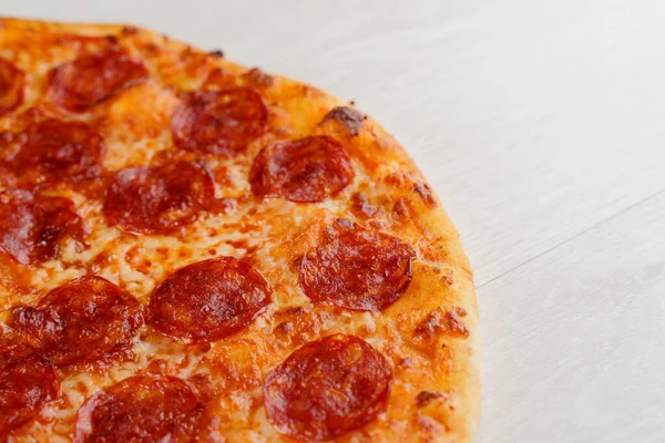 Beyaz ahşap arka planda izole edilmiş salamlı, peynirli ve soslu peperoni pizza. Lokantalar, kafeler için sosyal ağ ilanı. Pizzacı için tanıtım