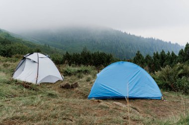 Yağmurlu ve sisli bir günde Karpatlar 'ın arka planında turist çadırları. Kırsal bölgede Coronavirus covid-19 karantinasında turizm.