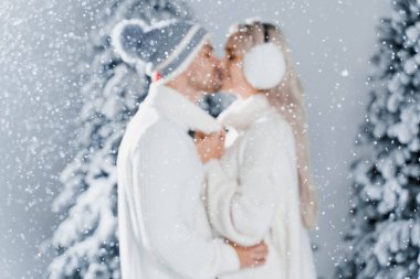 Mutlu genç çift kucaklaşmaları, gülümsemeleri ve kar, yeni yıl kutlamalarının arifesinde yılbaşı ağaçlarının yakınına düşer. Gülen adam ve kadın beyaz kazaklar giyerler birbirlerini severler.