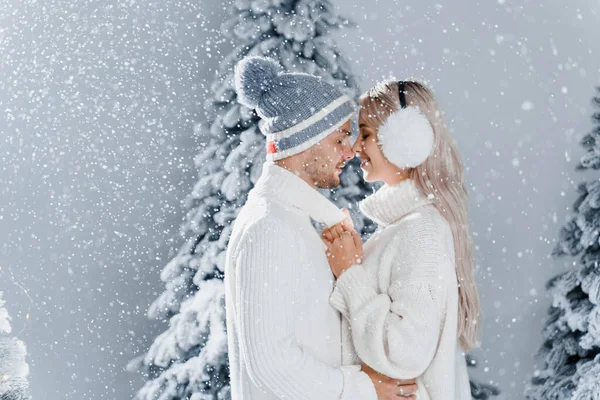 Abraços Casal Jovens Felizes Sorrisos Neve Cai Perto Árvores Natal — Fotografia de Stock