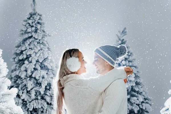 Abraços Casal Jovens Felizes Sorrisos Neve Cai Perto Árvores Natal — Fotografia de Stock