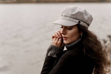 Çekici kız turist ülkesini geziyor ve Coronavirus covid-19 karantinasının sonunu düşünüyor. Kıvırcık saçlı genç bir kadın göle bakar ve hayatını düşler..