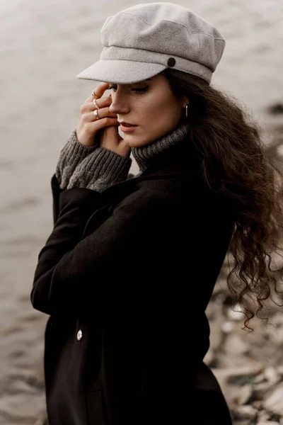 一个穿着黑色外套 头戴灰色羊毛帽的漂亮姑娘在湖边特写 在你的国家旅行 — 图库照片