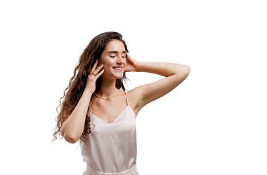 Açık tenli ve uzun dalgalı saçlı çekici bir kız. Kıvırcık saçlı esmer. Genç bir kadın yüzüne dokunuyor. Spa, cildiyeci, kozmetik salonu..