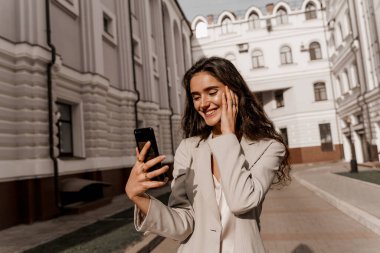 Kız internette akıllı telefon kullanarak servis yapıyor. Müdür telefonda çevrimiçi çalışıyor. Kıvırcık saçlı çekici bir kız şehirde izole edilmiş sosyal ağlarda telefonuna cevap veriyor.