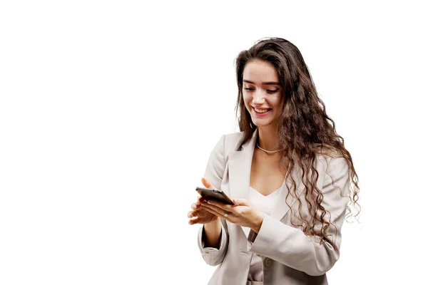 Kız internette akıllı telefon kullanarak servis yapıyor. Müdür telefonda çevrimiçi çalışıyor. Kıvırcık saçlı çekici kız telefonu tutuyor ve beyaz arka planda izole edilmiş sosyal ağlarda mesajlara cevap veriyor.