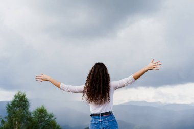 Karpatya dağlarında özgürlüğü hissetmek. Ukrayna 'da seyahat eden turizm. Kız ellerini kaldırdı ve dağ manzarasının tadını çıkarıyor..