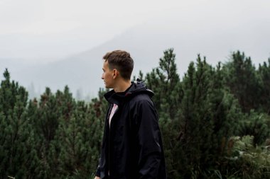 Erkek turist dağın zirvesine doğru yürüyor ve seyahat ediyor. Dağın tepesine doğru yürüyüp tırmanıyor. Ukrayna 'da turizm.