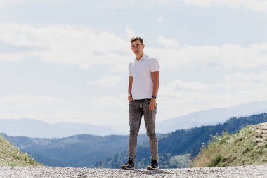 Yakışıklı adam Green Hills arka planında yürüyor. Seyahat acentesine yönlendir. Turizm. Dağlarda gezmek.