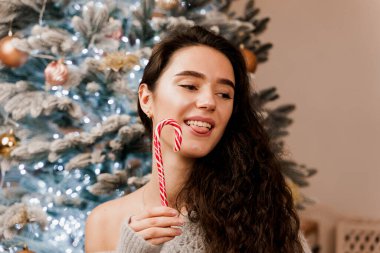 Geleneksel Noel şekeri güzel bir kızın ellerinde. Yeni yıl kutlamaları. Yeni Yıl Satışları Reklamcılığı