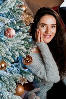 Noel ağacının yakınındaki bir kızın portresi. Yeni yıl kutlaması. Hediye bekliyorum..