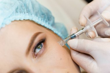 Elmacık kemiklerine yakın çekim enjeksiyonu. Burun, çene, elmacık kemikleri ve tapınakların hacmini ve şeklini düzeltmek için turne plastiği. Kozmetik yenileme yüz tedavisi.