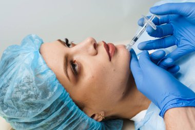 Hyaluronik asit enjeksiyonu. Burun, çene, elmacık kemikleri ve tapınakların hacmini ve şeklini düzeltmek için plastik kaplama. Tıbbi klinikte kozmetik yenileme yüz tedavisi