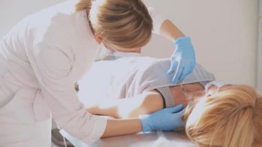 Kadın derisindeki elementleri çıkarmadan önce deriyi şırıngayla uyuşturuyor. Kozmetoloji ve dermatoloji