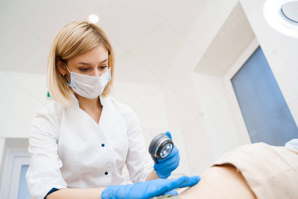 Dermatologist makes an examination using a dermatoscope. Consultation with a doctor. Rejuvenating procedure