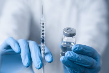 Koronavirüs aşısı tutan doktor. Covid-19 Aşılama. Karantinayı durdurun. Yakın çekim dalgalanması ve ilaçlar
