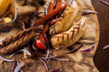 Sarı hardallı ızgara sosisli sandviç ve ahşap arka planda ketçap. Patates kızartması ve soslu sandviç..