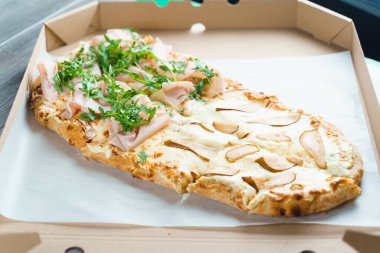 Armut, peynir ve jambonlu Pinsa Romana. Beyaz arka planda Scrocchiarella İtalyan mutfağı. Geleneksel yemeği tutuyorum. Pizzacıdan yemek teslimatı.