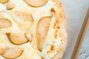 Armut, peynir ve jambonlu Pinsa Romana. Beyaz arka planda Scrocchiarella İtalyan mutfağı. Geleneksel yemeği tutuyorum. Pizzacıdan yemek teslimatı.