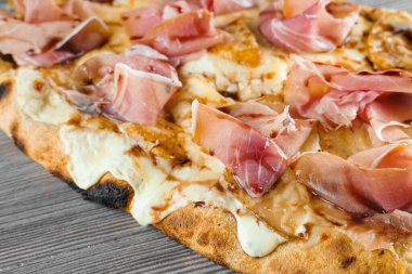 Armut, peynir ve ahşap kaplamalı jambonlu scrocchiarella. Pinsa romana İtalyan mutfağı. Pizzacıdan yemek teslimatı. Abur cubur