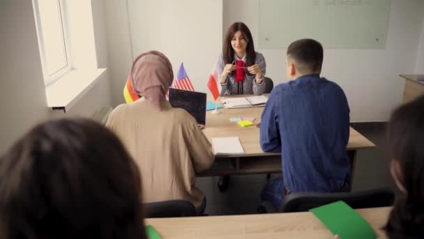 Estudiantes multiétnicos y profesores estudian idiomas extranjeros juntos en clase. Repleto de cuaderno. negro atractivo chica estudiante estudio con blanco personas juntos y mirar en cámara — Vídeo de stock