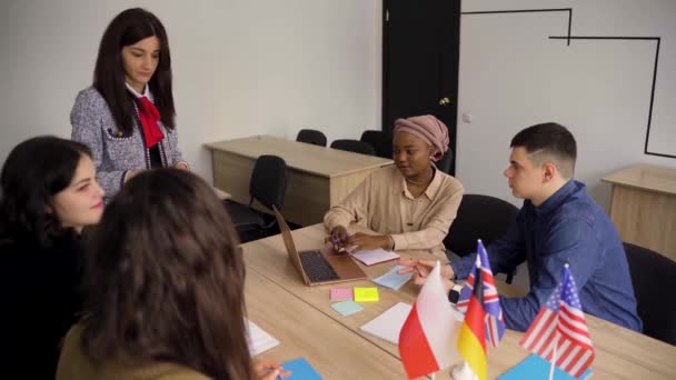 Trabajo en equipo. Trabajar en un grupo multiétnico de estudiantes. profesor estudiar idiomas extranjeros juntos en clase. Relleno con portátil. negro guapo chica estudiante estudio con blanco personas juntos — Vídeos de Stock