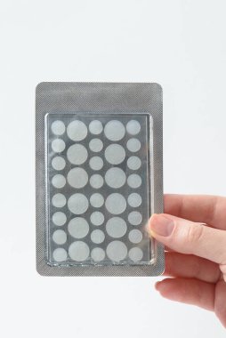 Sivilceler için yuvarlak yamalar ve beyaz arka planda kırışıklıklar. Sivilce ve yüz yenileme için kırışıklık bantları. Yüz temizleme kozmetolojisi.