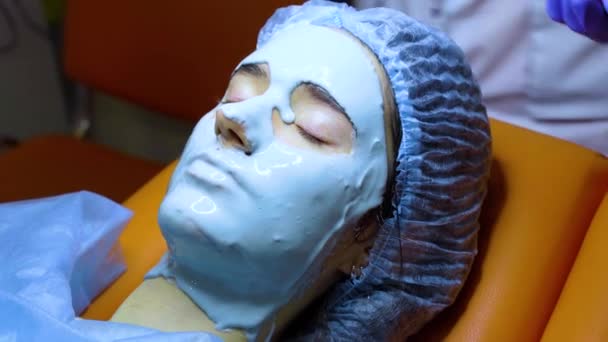 Alginate masque hydratant pour le visage et la peau de la jeune fille. Procédure spa pour le rajeunissement. esthéticienne frotte masque bleu. Dermatologie en clinique médicale — Video
