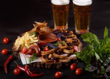 Büyük bir tabak, geniş bir bira çeşitleri ile tahta bir tahta üzerinde koyu bir arka plan karşı karşıya.