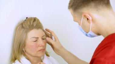 Tıbbi klinikteki yüz bölgesini değiştiren estetik ameliyattan önce yüzünde Blepharoplasti izi var. Estetik ameliyat yapan bir doktor.