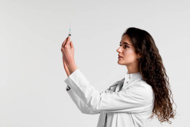 Doktor elinde Coronavirus aşısı olan şırınga tutuyor. Covid-19 Aşılama. Karantinayı durdurun. Şırıngalı ve ilaçlı tıp eldivenli çekici kız.