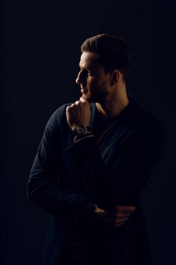 Esmer arka planda iş adamı portresi. Stüdyoda takım elbise giyen yakışıklı bir genç. Stüdyoda kendine güvenen profesyonel moda erkeği.