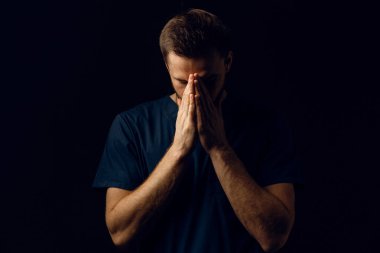 İnsan elleriyle yüzünü kapatır ve hayatı düşünür. Yakışıklı adam dua eder ve Tanrı 'ya inanır. Ortodoks Hıristiyan inancı.