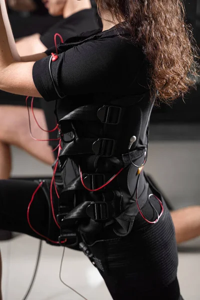 Spor salonunda EMS giysisiyle fiziksel egzersiz yapıyor. Elektrik kas stimülasyonu giysisinde spor eğitimi