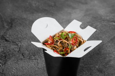 Siyah yemek kabında baharatlı erişteler. Fast food teslimat servisi. Çin yemeği siparişi.