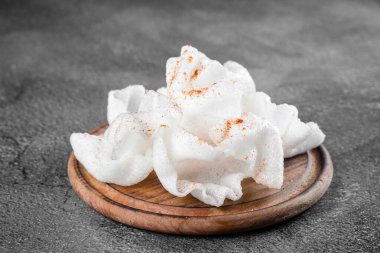 Yağda kızartılmış pirinç kağıdı parçaları. Gri arkaplanda tahta üzerinde pirinç parçaları