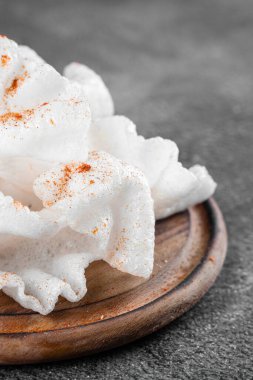 Yağda kızartılmış pirinç kağıdı parçaları. Gri arkaplanda tahta üzerinde pirinç parçaları