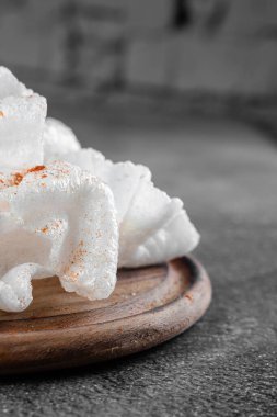 Yağda kızartılmış pirinç kağıdı parçaları. Gri arkaplanda tahta üzerinde pirinç parçaları