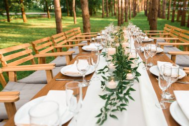 Kırsal yeşil dal ve masada mumlar. Düğün süslemesi