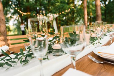 Ormanda düğün ziyafeti düzenlemek. Kırsal tarzda. Yeşil dal ve mumlar. Bir düğün kutlaması..