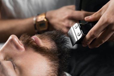 Tıraş makinesiyle sakalı buduyorum. Berber ve erkek güzellik salonu reklamları..