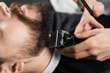 Tıraş makinesiyle sakalı buduyorum. Berber ve erkek güzellik salonu reklamları..