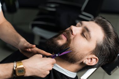 Bir berber dükkanındaki beyefendiye makaslı saç kesimi sakalı. Profesyonel kuaför..